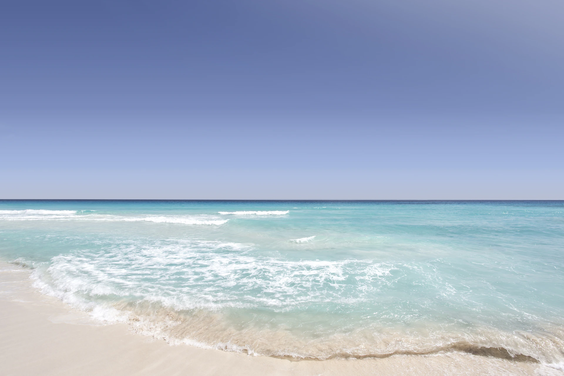 Playa de Cancún en un día soleado, con arena blanca y mar turquesa